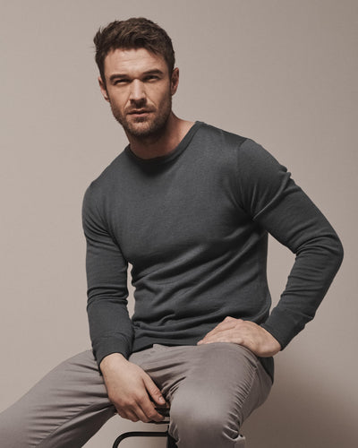 Model wearing our unisex extra-fine merino wool crew neck jumper, made from a lightweight fabric and reactive natural fibre. Ideal for layering under our waterproof dry robes for spectating touchdown sports or walking the dog. The perfect addition to any minimalist capsule wardrobe.