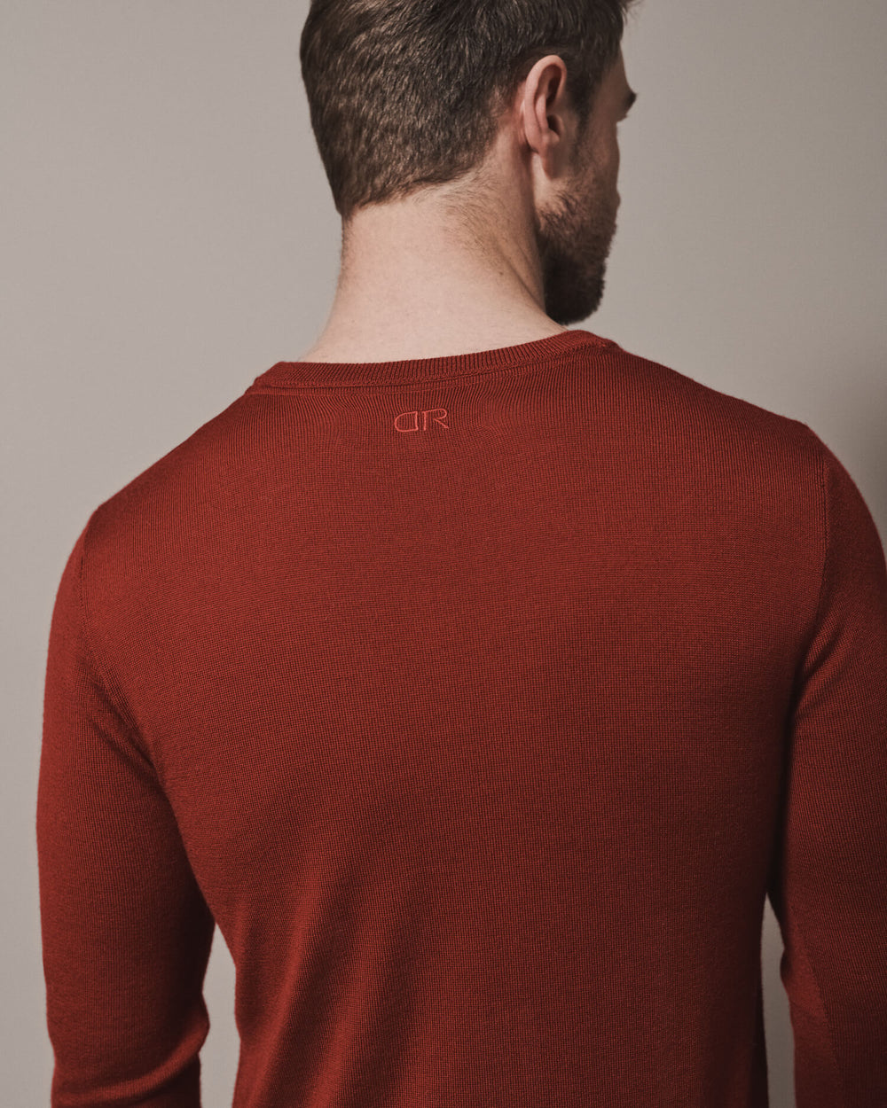 Our extra-fine merino wool crew neck jumpers for men and women in maroon red are made from a lightweight fabric and reactive natural fibre. Finished with our signature brand logo with red stitching. Ideal for layering under our waterproof dry robes for spectating touchdown sports or walking the dog.