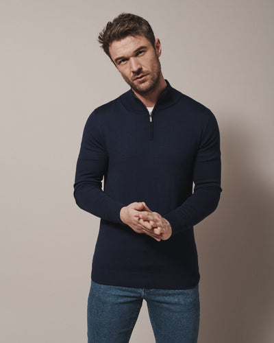 Model wearing our unisex extra-fine merino wool 1/4 zip jumper, made from a lightweight fabric and reactive natural fibre. Ideal for layering under our waterproof dry robes for spectating touchdown sports or walking the dog. The perfect addition to any minimalist capsule wardrobe.