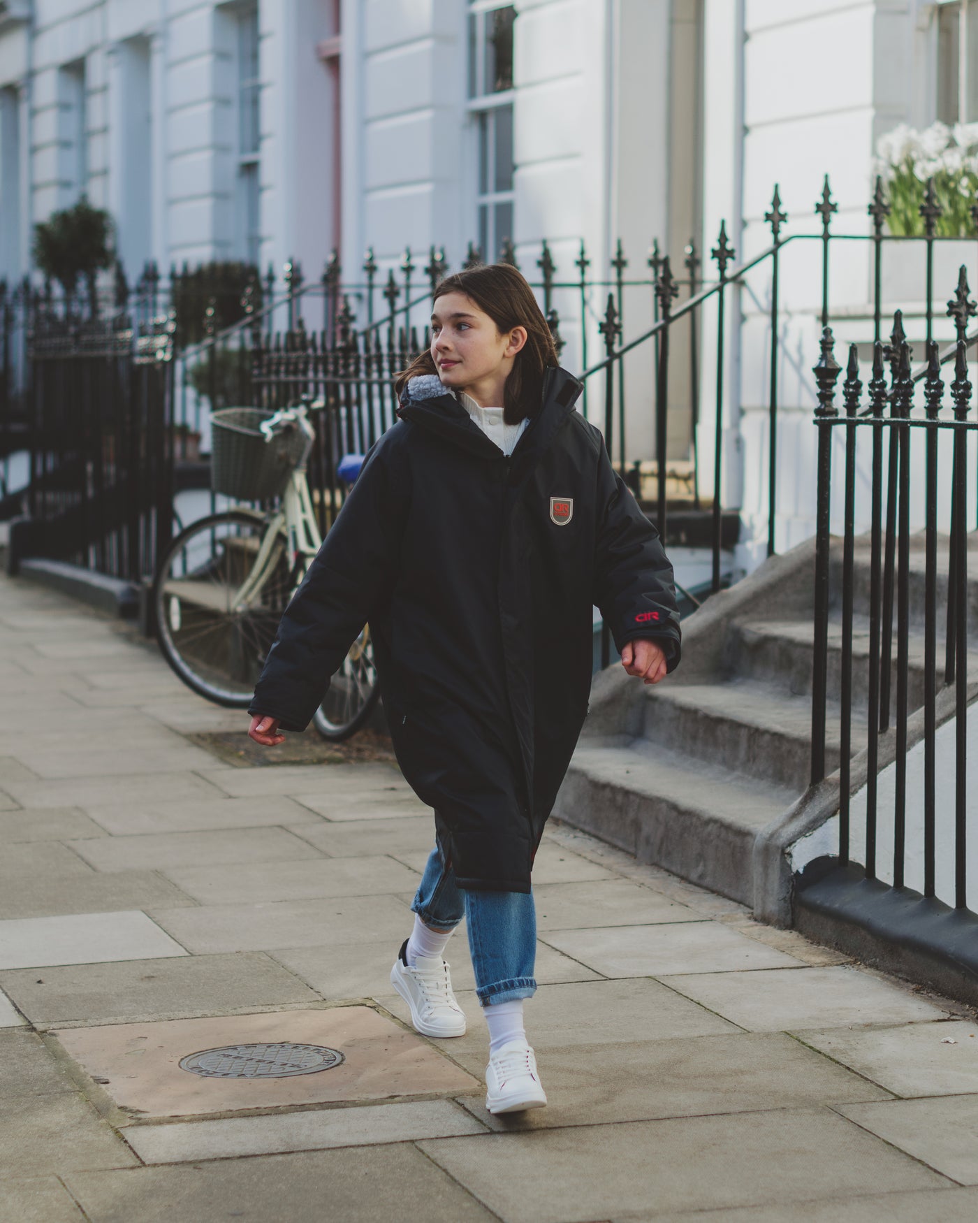 A girl in London wearing one of our junior anthracite Beaufort Robes  with fleece-liner and waterproof inside pockets. D-Robe are the best outdoor robes for kids.